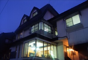 A multi-story house with large windows and a balcony. - Lodge Marushige (Nozawaonsen)