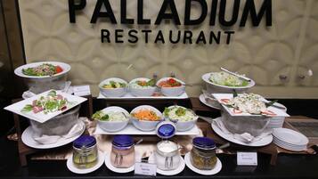 Un aparador al RESTAURANT PALLADIUM amb diverses amanides i condiments.