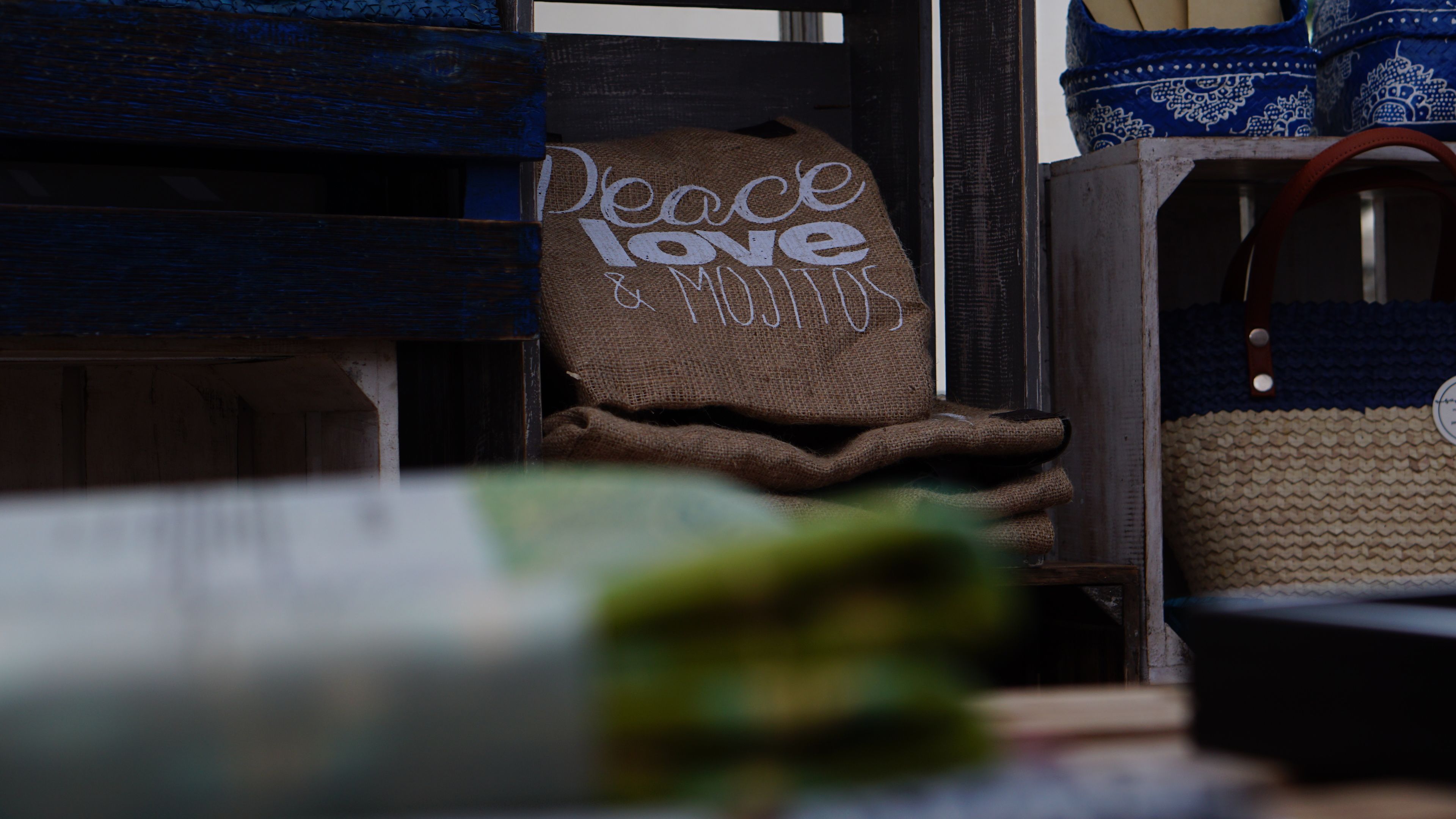 Un interior rústico con una bolsa de arpillera que lleva la etiqueta 'Peace Love & Mirth' colgada de una viga de madera.