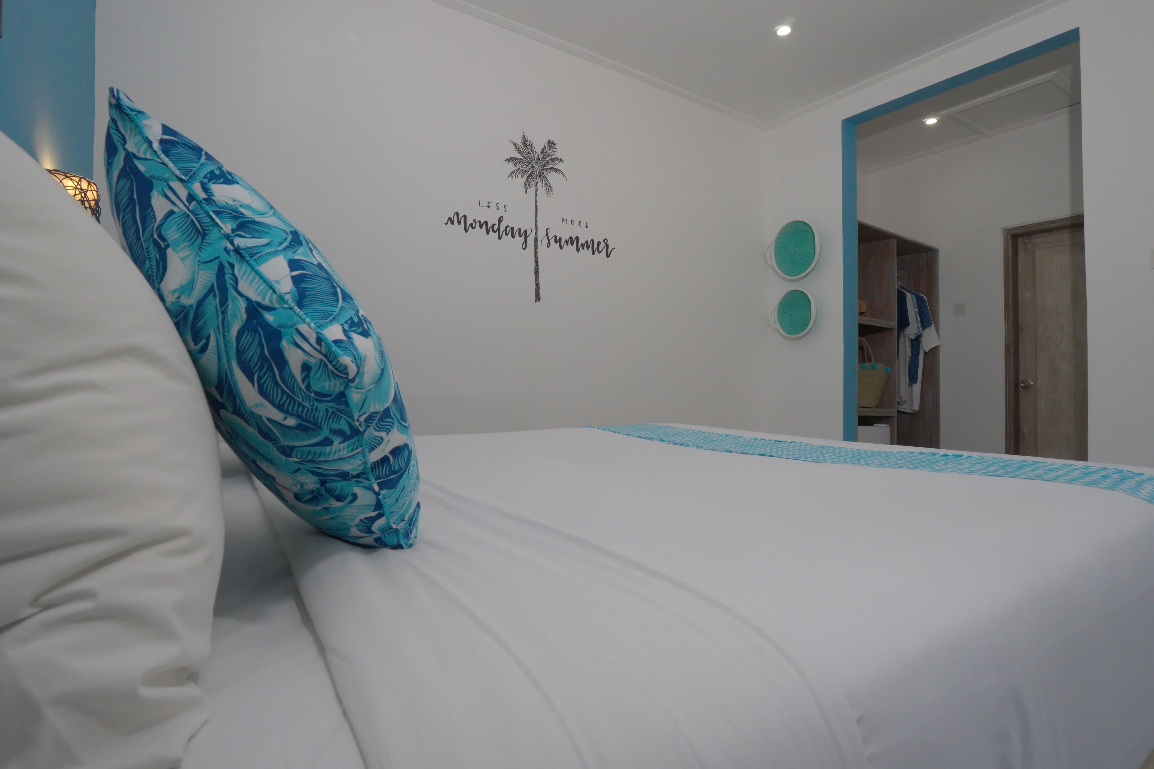Un dormitorio con cama, un adorno en la pared y una puerta que da a otra habitación.