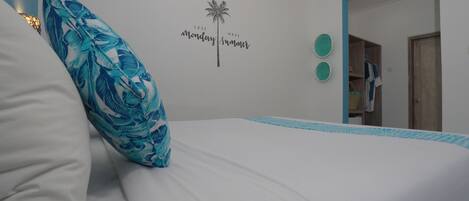 Un dormitorio con cama, un adorno en la pared y una puerta que da a otra habitación.