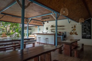 An outdoor dining area with wooden benches and a bar counter.