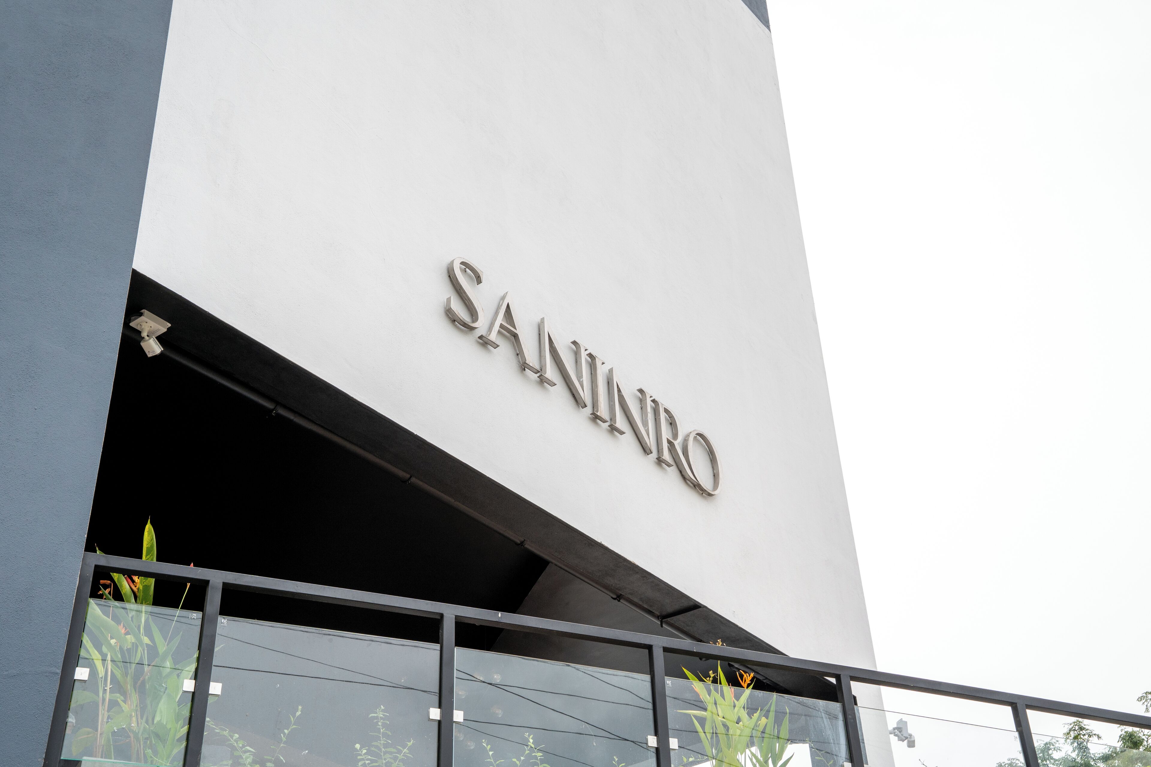 Um edifício com o nome 'SANINRO' na fachada.