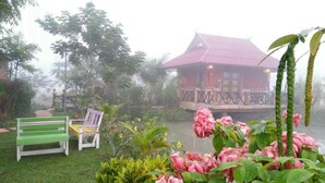 A rustic cabin with a red roof, surrounded by lush greenery and a small pond. - Maesai Doi View Resort (Mae Sai)