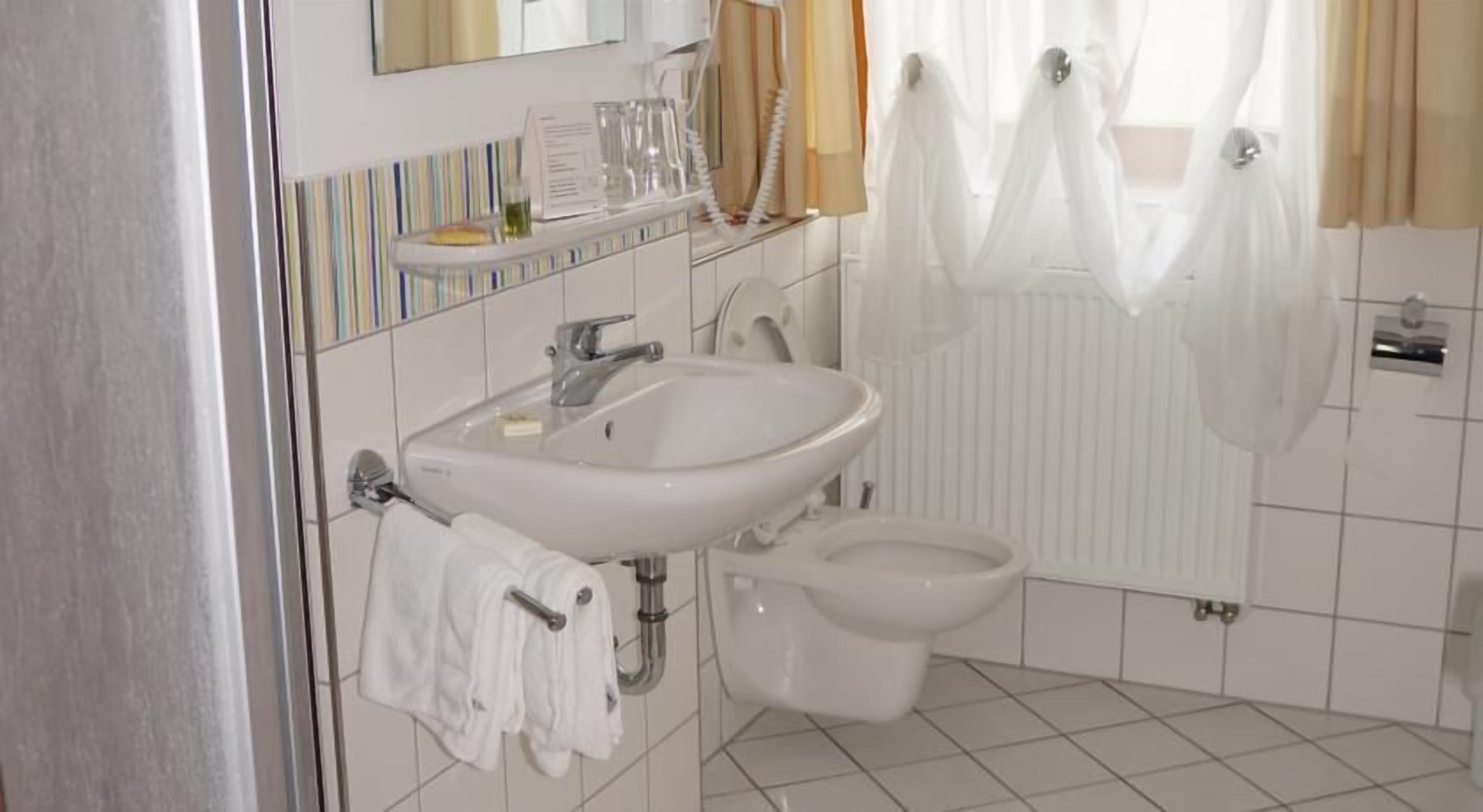 Ein Badezimmer mit Waschbecken, Toilette und Duschvorhang.