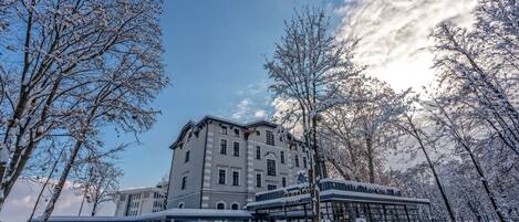 A hotel with multiple floors, large windows, and a snow-covered landscape.