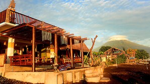 A rustic wooden building with a thatched roof, a wooden deck, and a sign indicating it is a restaurant. - Amed Sunset Beach (Karangasem)