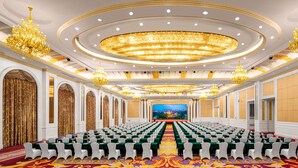 A large conference room with rows of white chairs, a stage with a cityscape backdrop, and ornate chandeliers. - Country Garden Phoenix Hotel Chongqing (Chongqing)