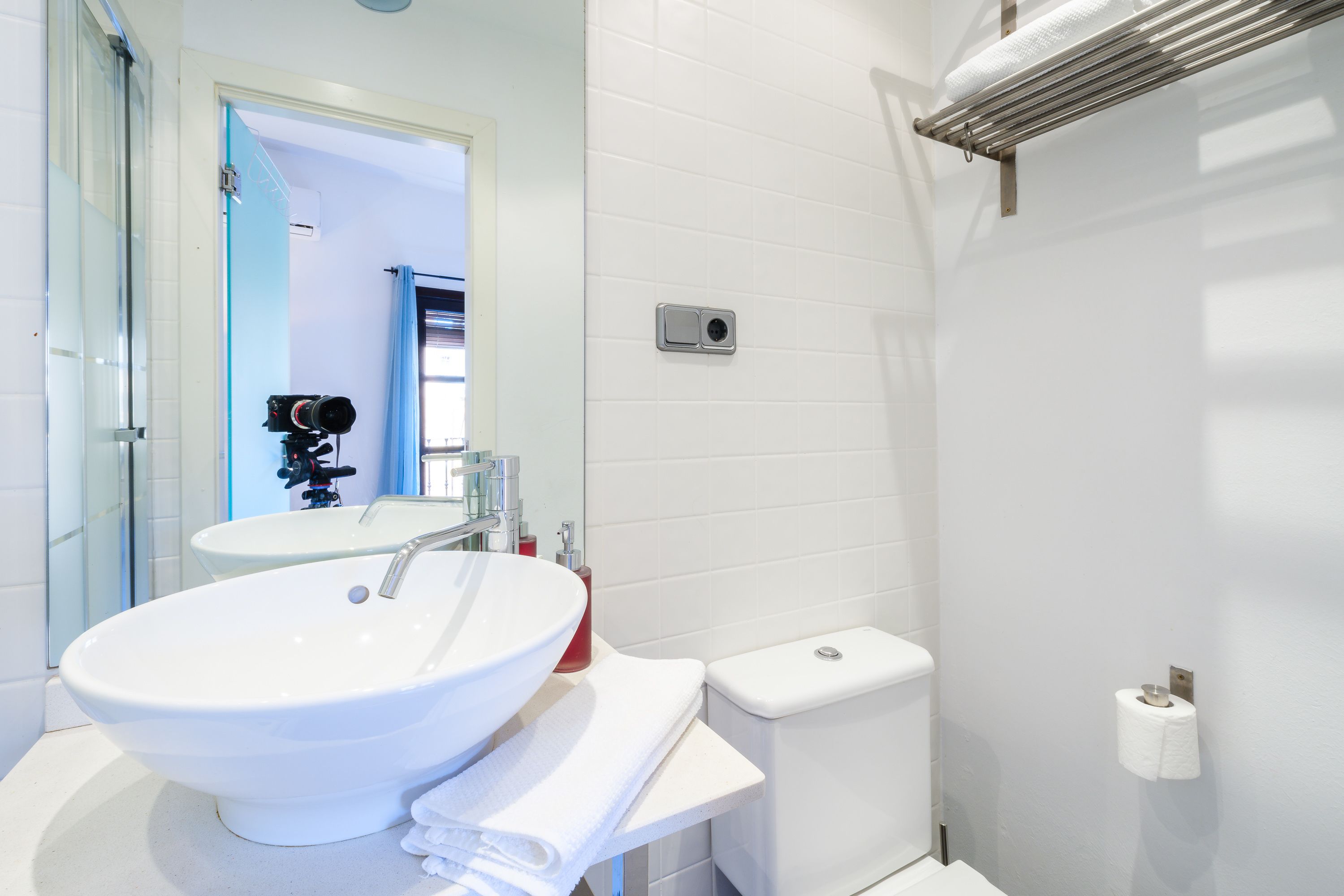 Ein modernes Badezimmer mit Waschbecken, Spiegel und Toilette.