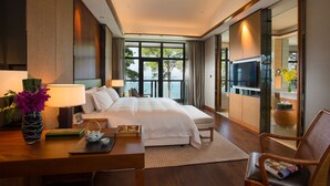 Une chambre d’hôtel moderne dotée d’un grand lit, d’un bureau avec une lampe, d’une télévision et offrant une vue sur l’extérieur.
