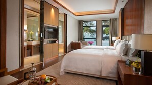 Une chambre d’hôtel avec un grand lit, une télévision, un bureau avec une lampe et une vue sur l’extérieur.