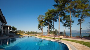 Une piscine offrant une vue dégagée sur la mer et les montagnes en arrière-plan.