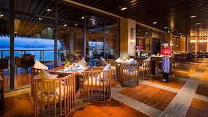 Un restaurant doté de meubles en bois et de grandes fenêtres offrant une vue panoramique.