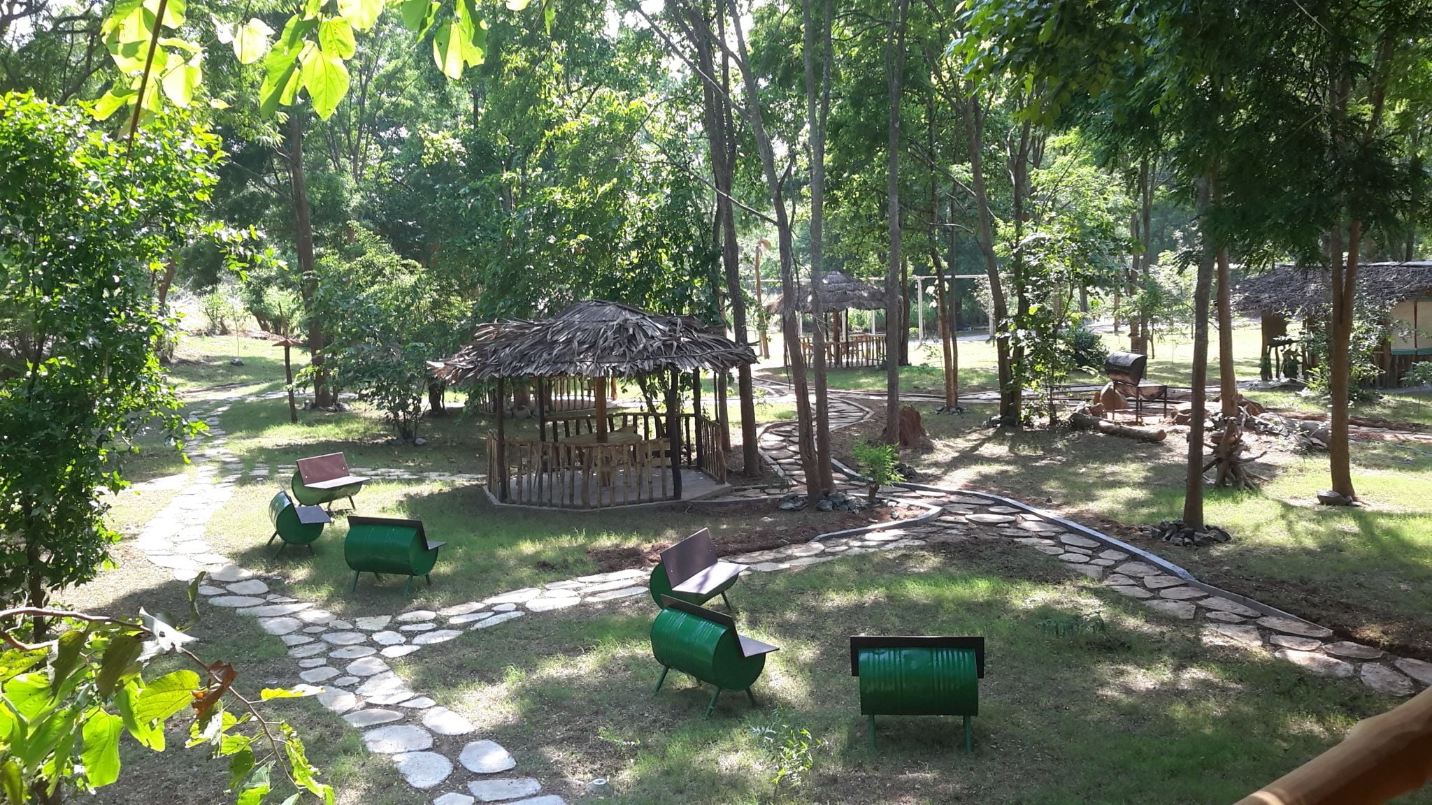 A park with a gazebo, stone pathways, and green benches.