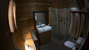 A wooden cabin bathroom with a sink, mirror, and shower.