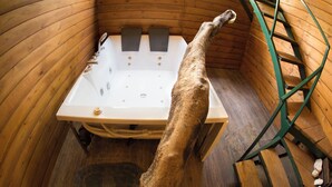 A wooden cabin with a large bathtub, a ladder, and a dog standing in the tub. - La Pentera (Thanamalvila)