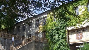 A historic building with a staircase leading to a door marked "BENVENUICA."