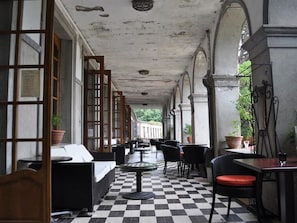 An indoor patio area with checkered flooring, black and white furniture, and potted plants.
