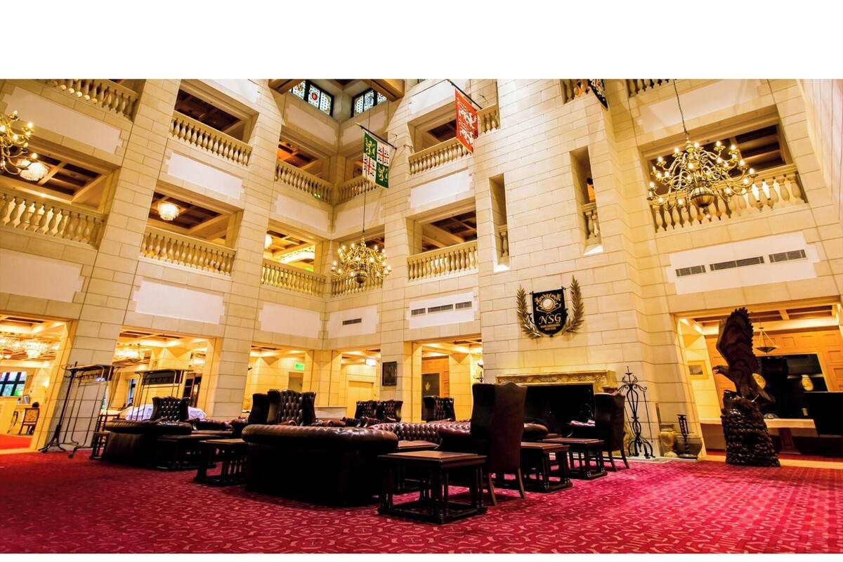 Eine beeindruckende Hotelhalle mit mehreren Sitzbereichen, einem Chandelier und einer Garderobe.