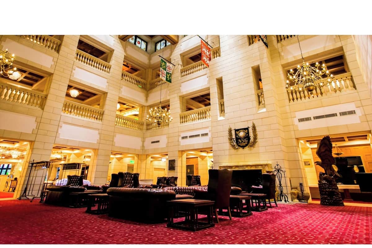 Eine beeindruckende Hotelhalle mit mehreren Sitzbereichen, einem Chandelier und einer Garderobe.