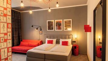 Een moderne slaapkamer met een bed, nachtkastjes, een bureau en een stoel.