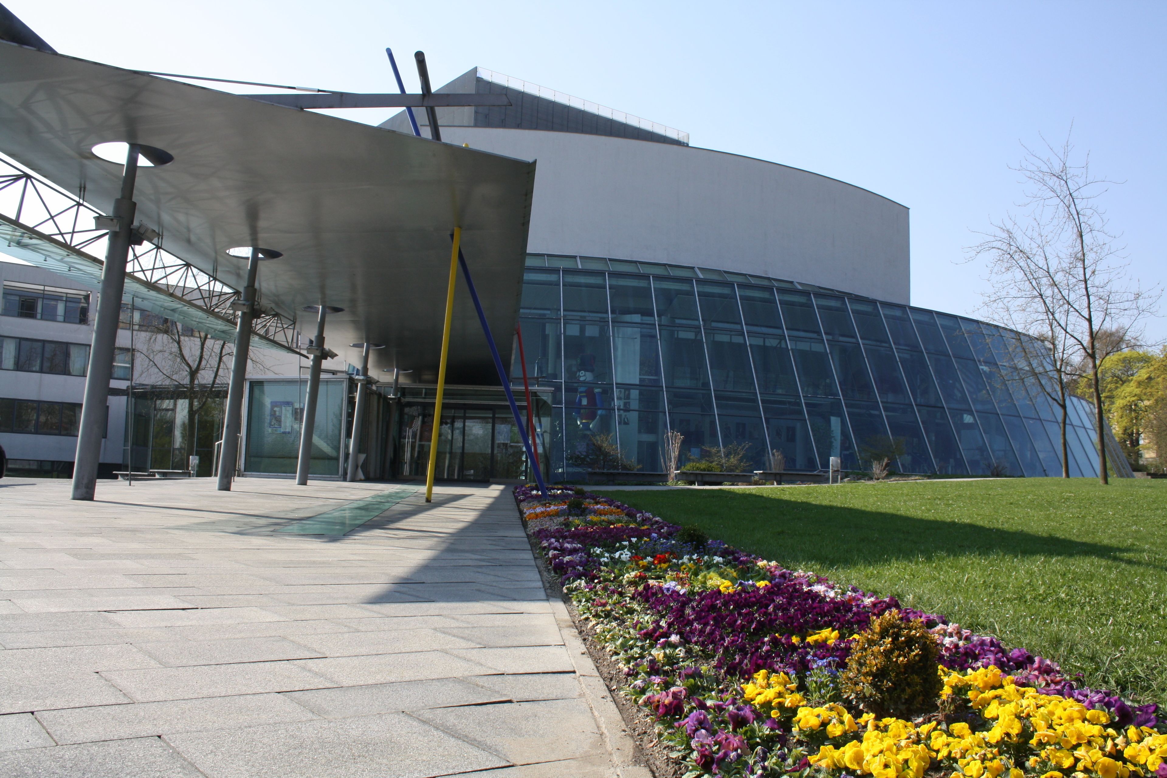 A modern building with a glass facade and a covered walkway.