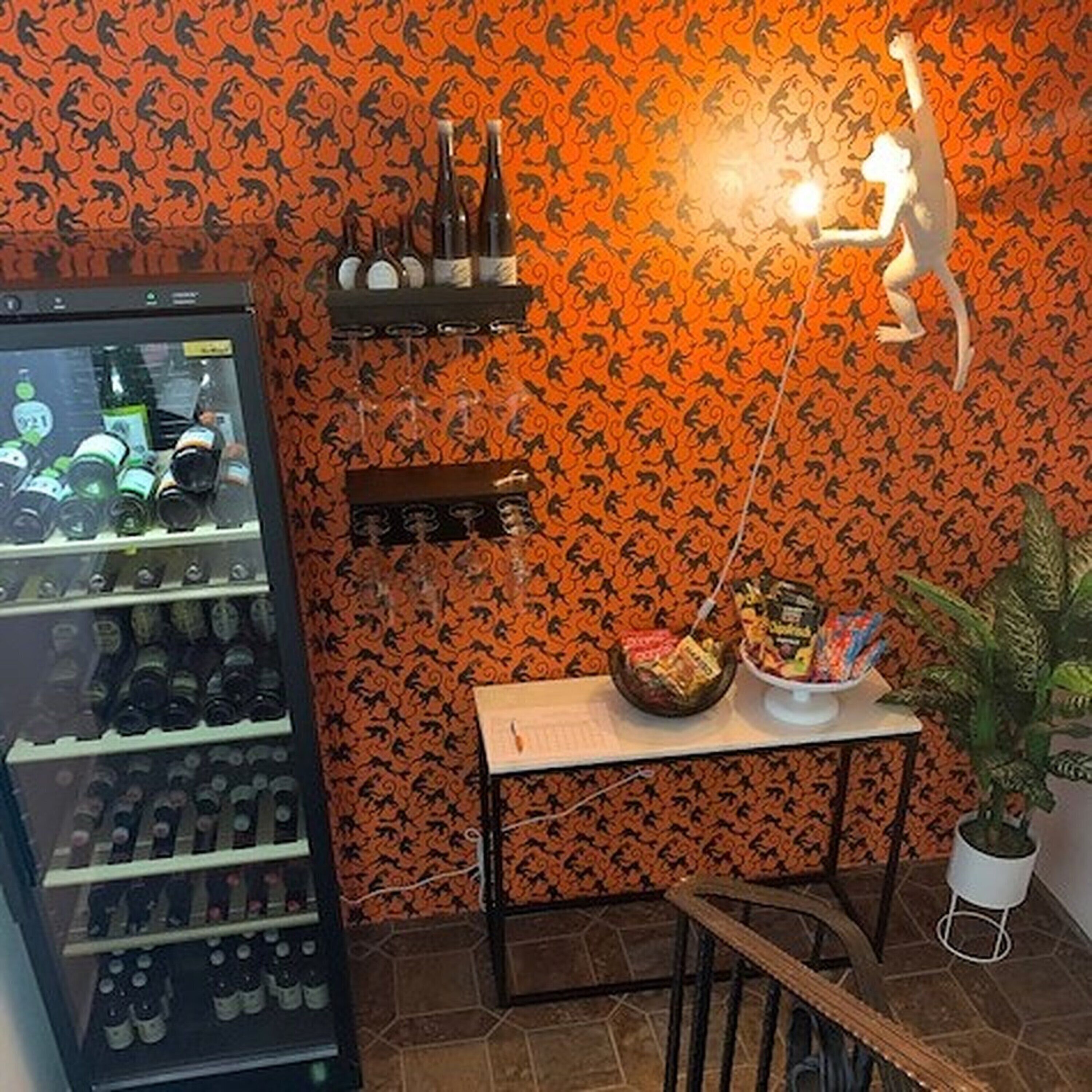 Ein Zimmer mit Getränkeautomaten, einer kleinen Tafel mit Snacks und einem dekorativen Wandbild.
