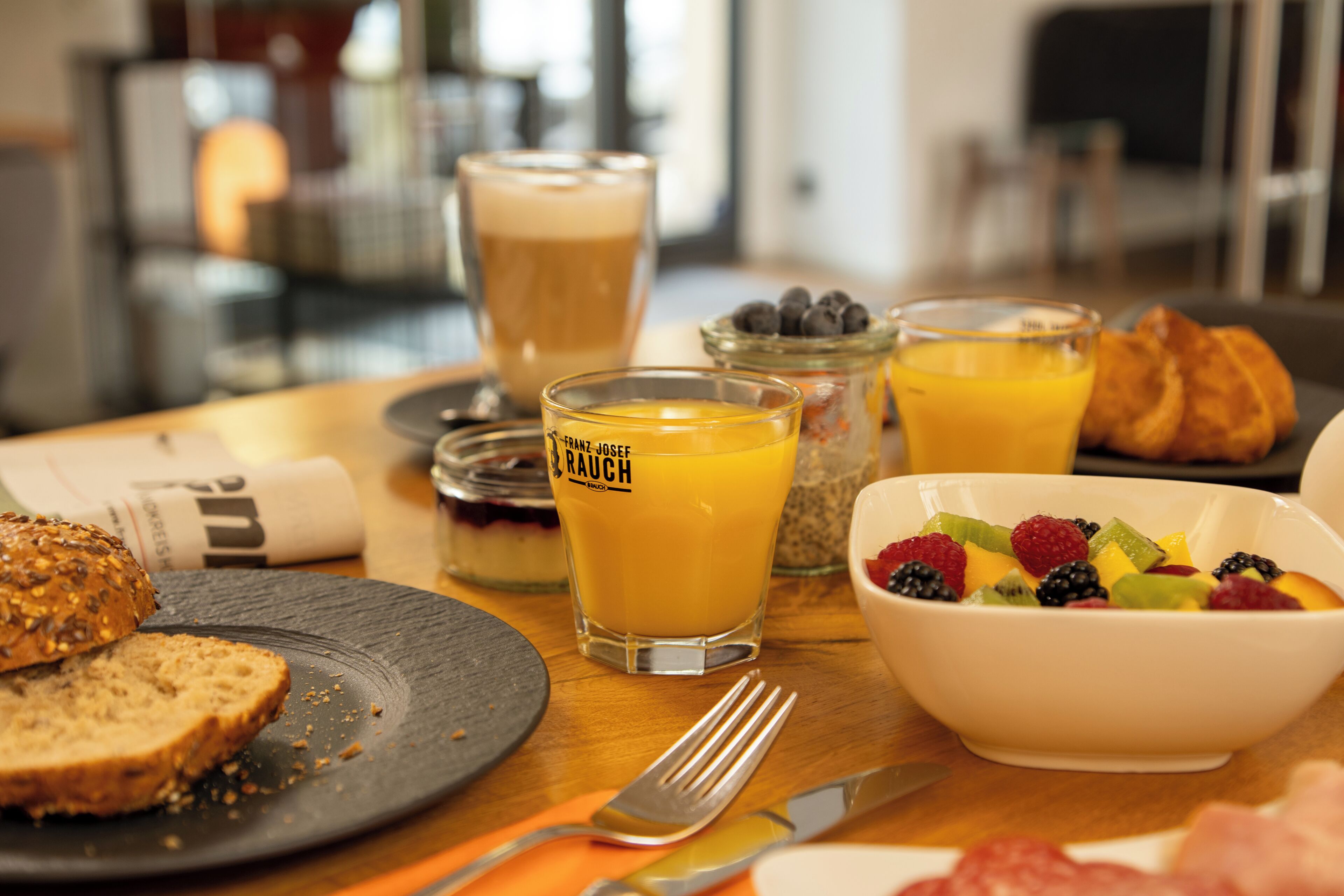 Desayuno con diversas opciones de comida, como tostadas, fruta y bebidas.