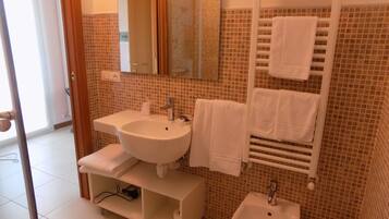 A bathroom with two sinks, a mirror, and a towel rack.