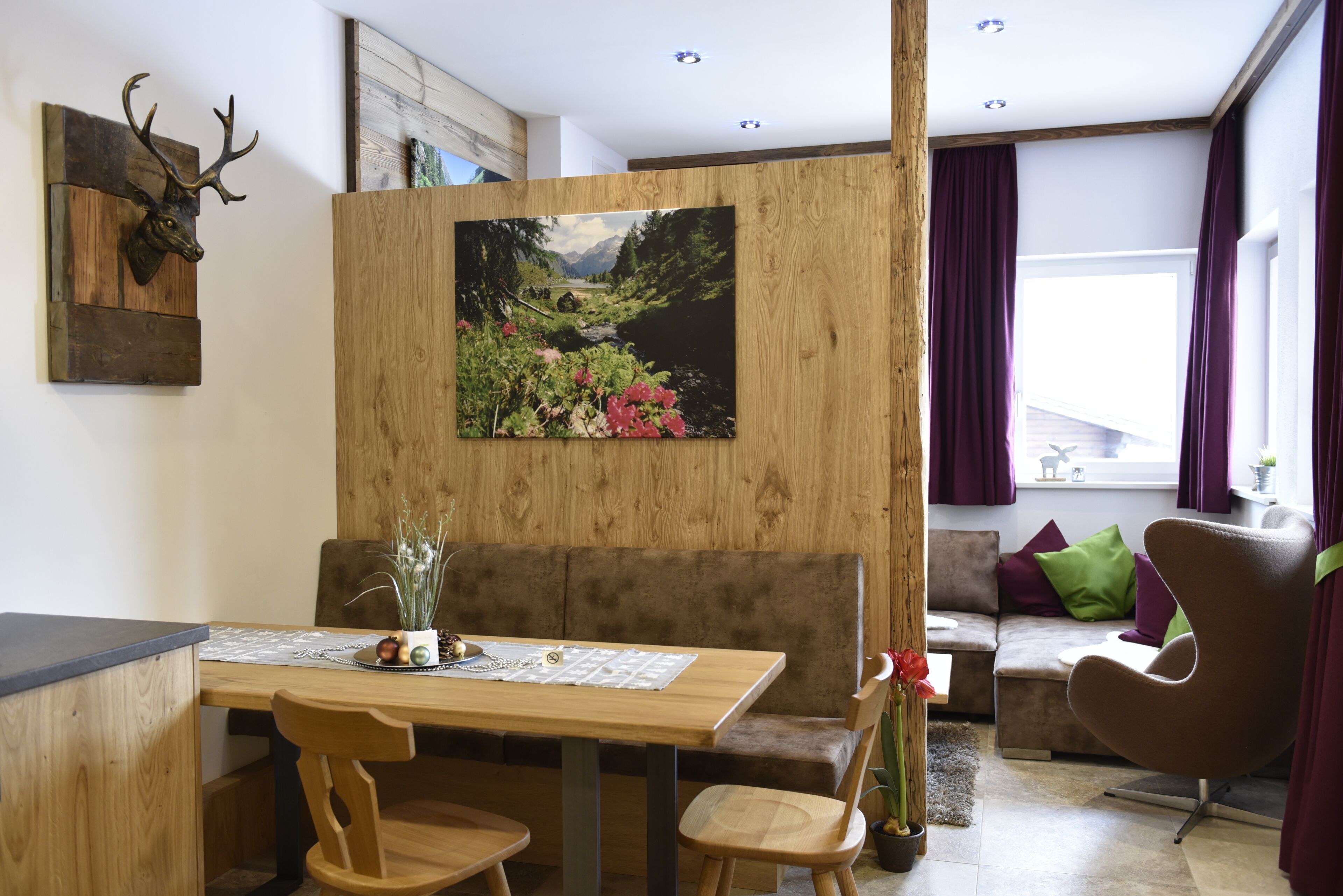 Un soggiorno moderno con un tavolo da pranzo in legno, un divano e un quadro raffigurante un paesaggio.