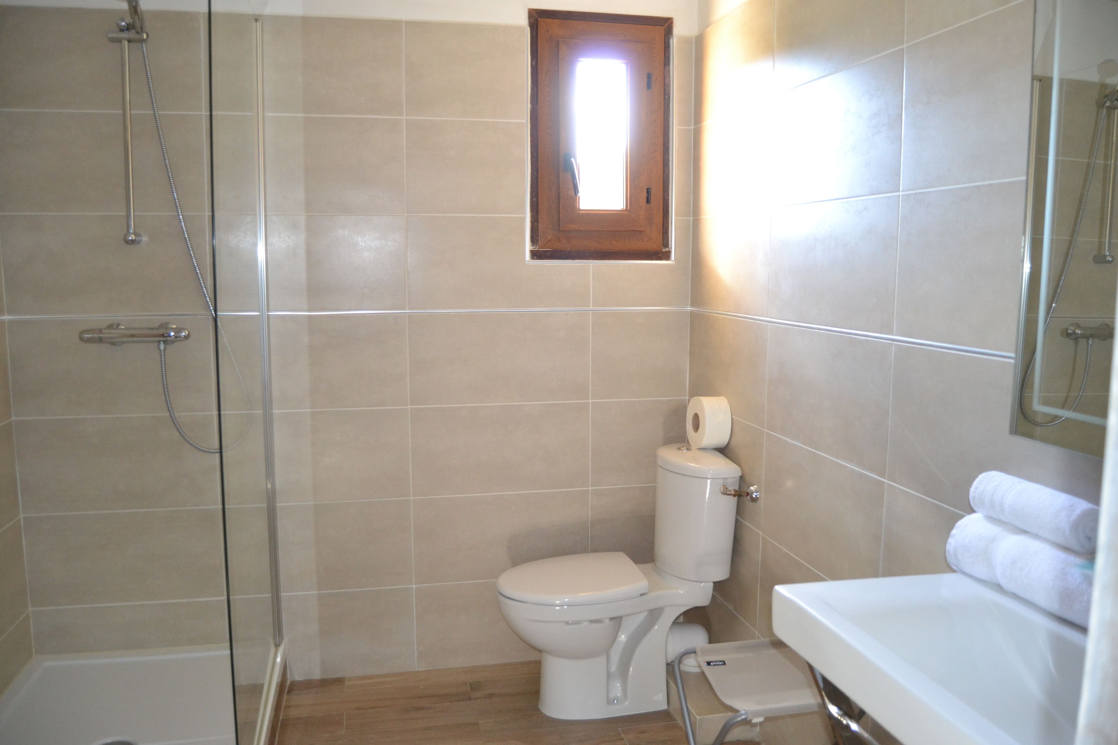 A bathroom with a shower, toilet, and sink.