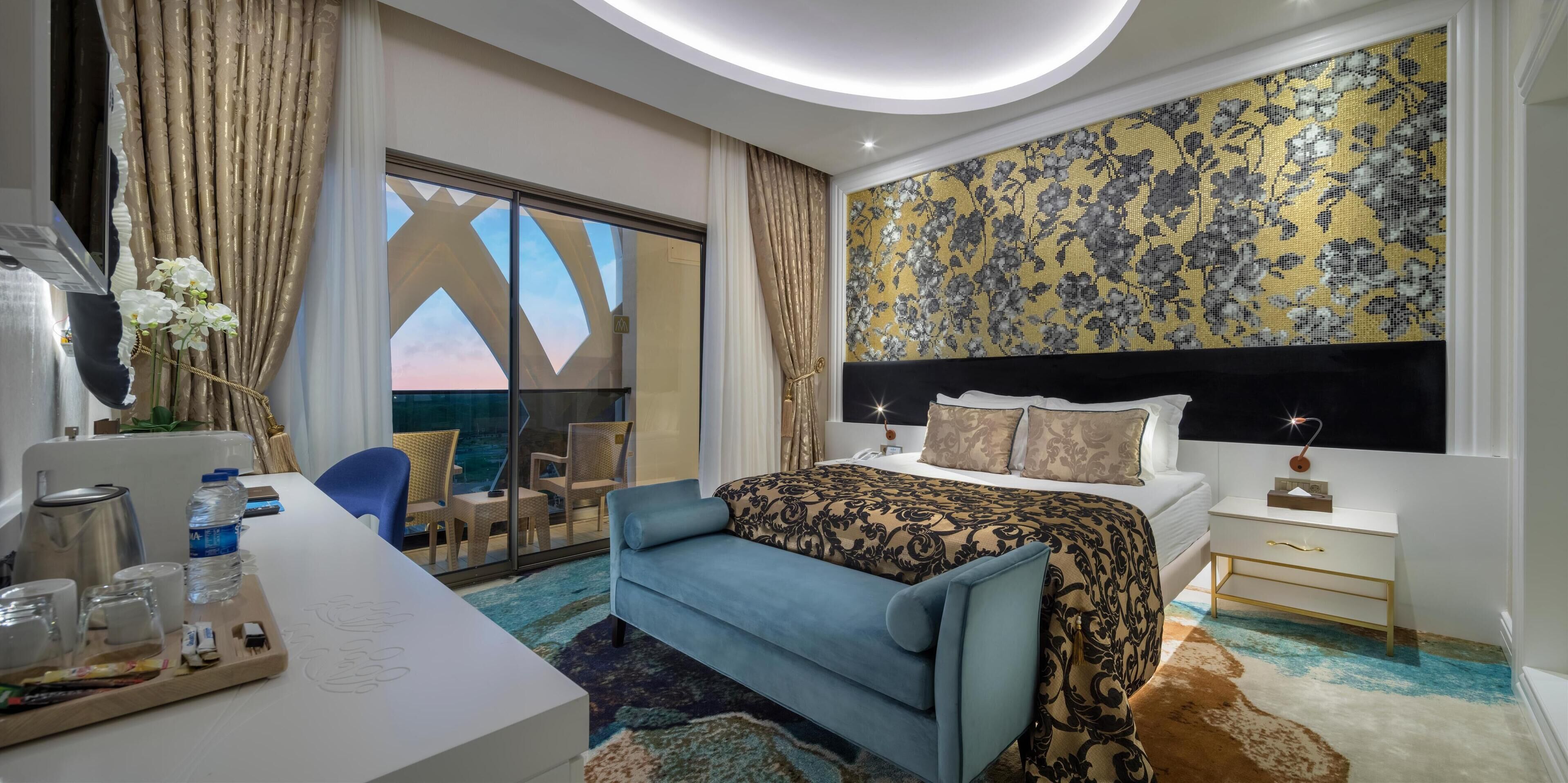 Une chambre d’hôtel comprenant un lit, un bureau avec un plateau d’articles divers, une chaise, un canapé et une vue sur l’extérieur.