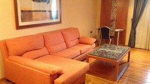 A living room with a sofa, a coffee table, and a framed picture on the wall. - Hotel Rusadir (Melilla)