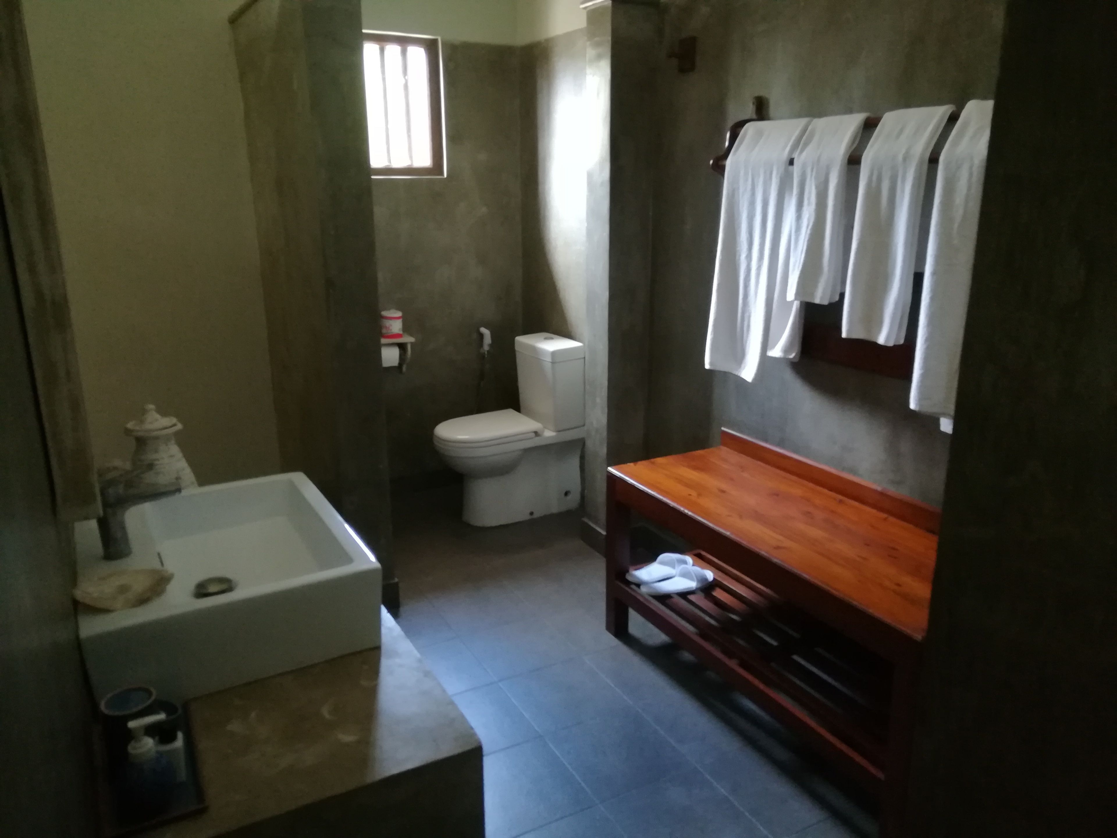 Un baño con bañera, inodoro y tocador de madera.