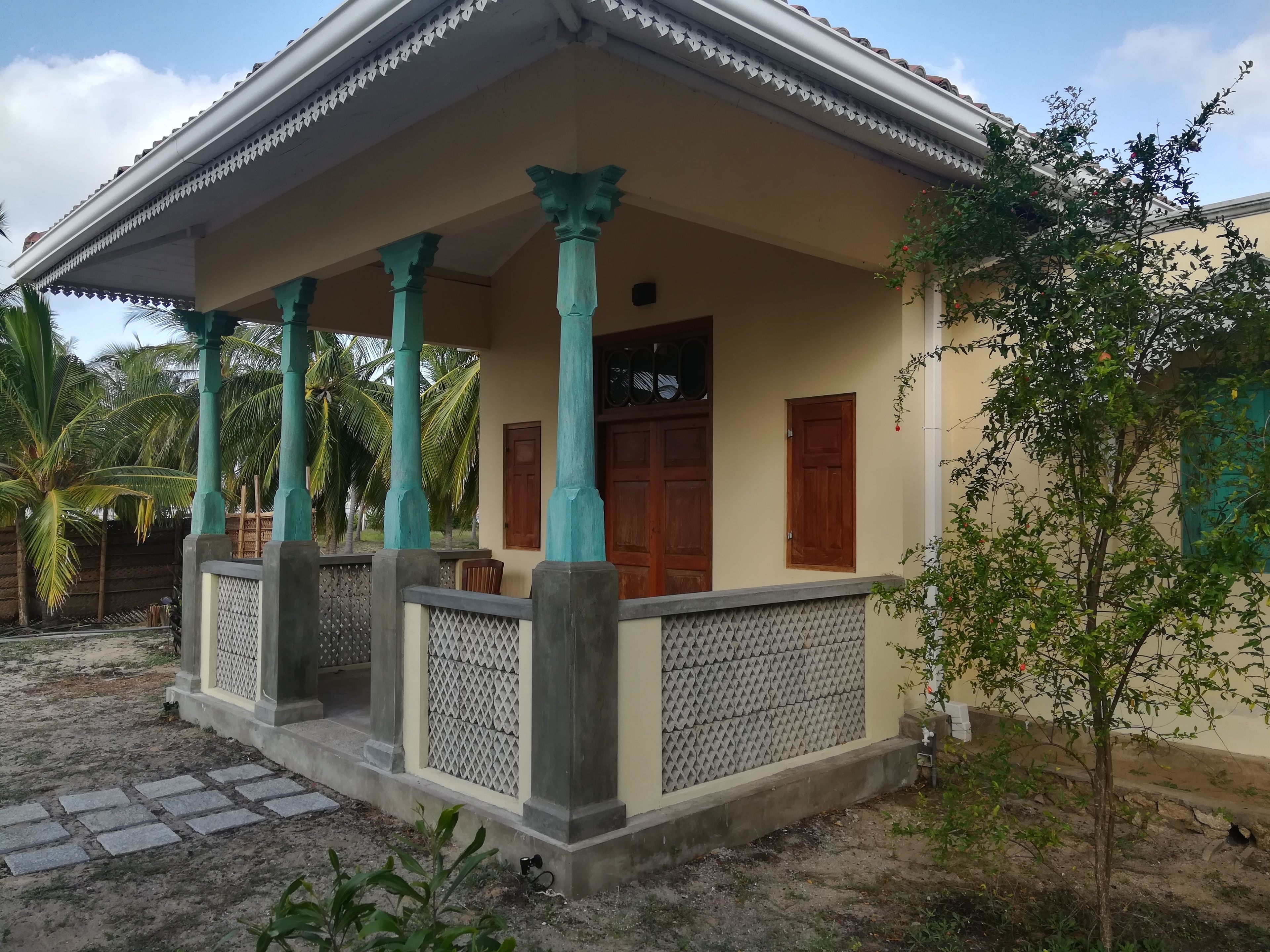Una casa con porche, columnas y una puerta.