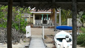 A wooden pathway leading to a house with a tiled roof and a porch. - Villa Setha Wadi (Kalpitiya)