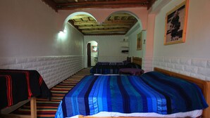A room with a large bed, a smaller bed, and a bench. There is a wooden ceiling and a white brick wall. - Maison d'Hôtes La Vallée des Figues (Ait Sedrate Jbel El Soufla)
