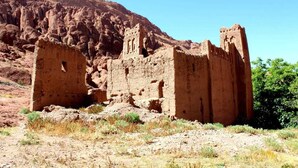 A historical adobe structure with a flat roof and rectangular windows, surrounded by a dry, rocky landscape. - Maison d'Hôtes La Vallée des Figues (Ait Sedrate Jbel El Soufla)