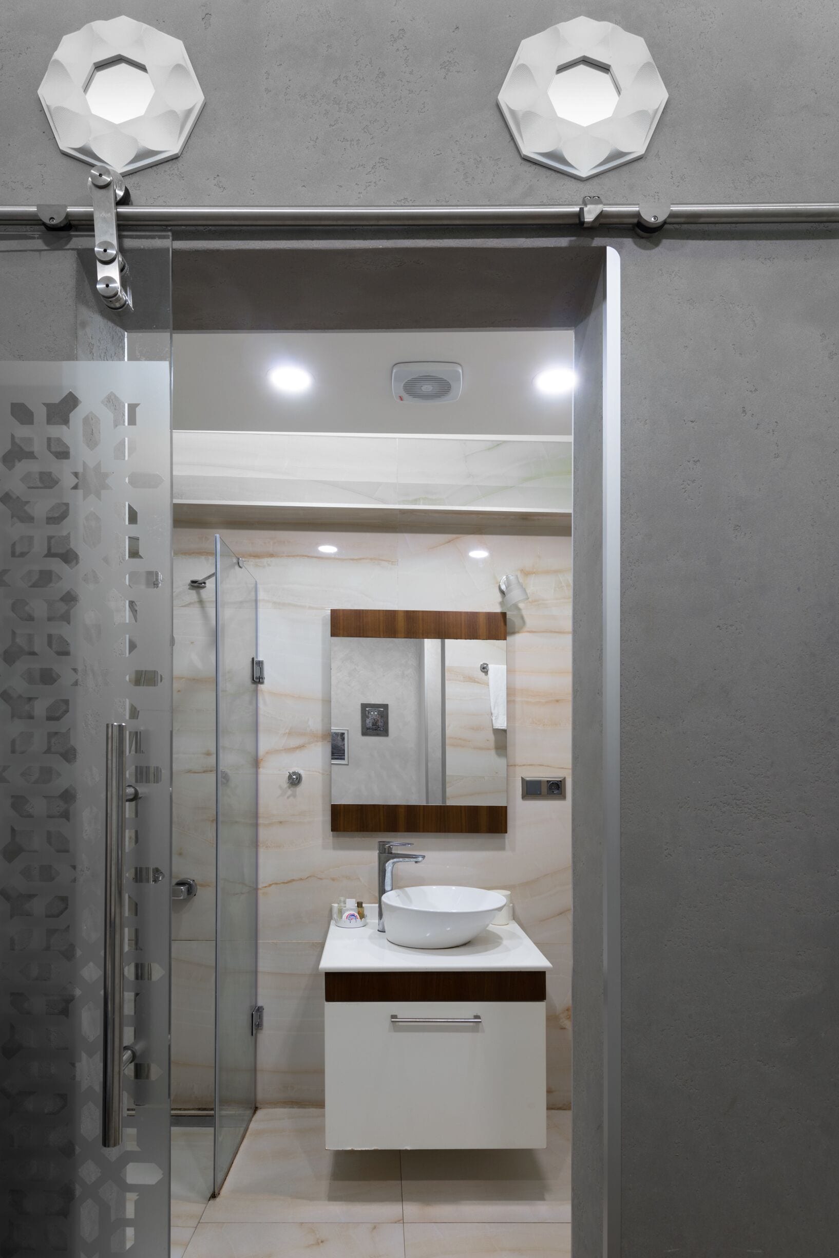Une salle de bain moderne avec une douche à parois de verre, un lavabo blanc et un meuble-lavabo en bois.