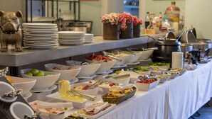 A buffet table with various food items and utensils.