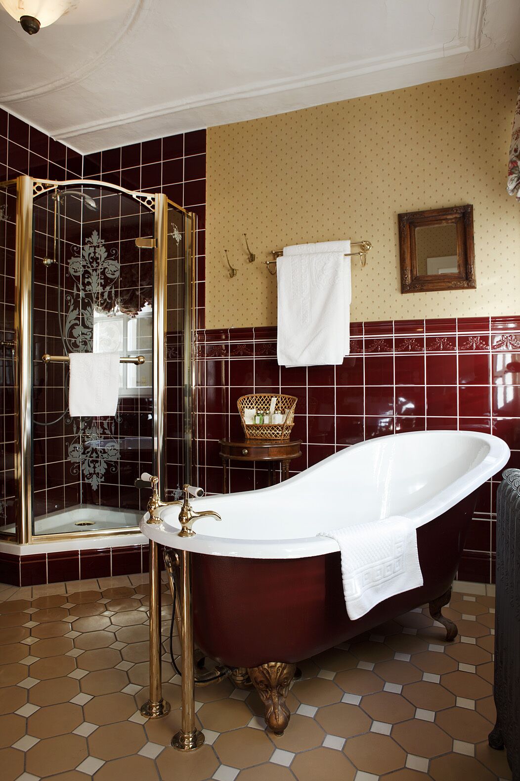 Une salle de bain avec une baignoire sur pieds, une douche à parois de verre et un meuble-lavabo avec un miroir et un porte-serviettes.