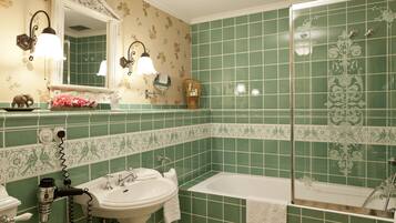 A bathroom with a sink, mirror, and bathtub.