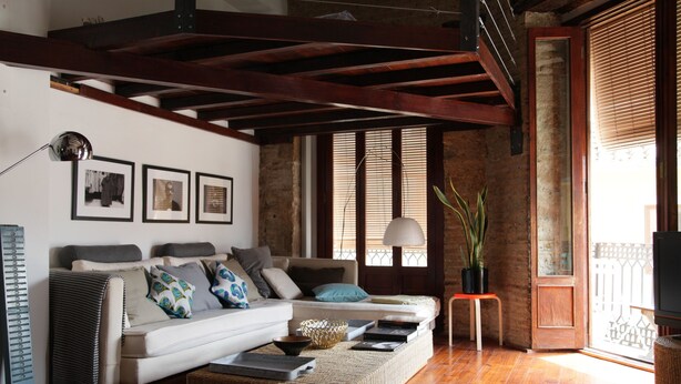 A living room with a sofa, a coffee table, and a television. There are framed pictures on the wall and a plant on a side table. - Bubuflats Mossen (Valencia)