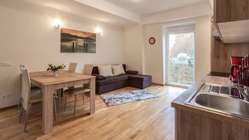 Cozy living space with a dining table, sofa, and kitchen area.
