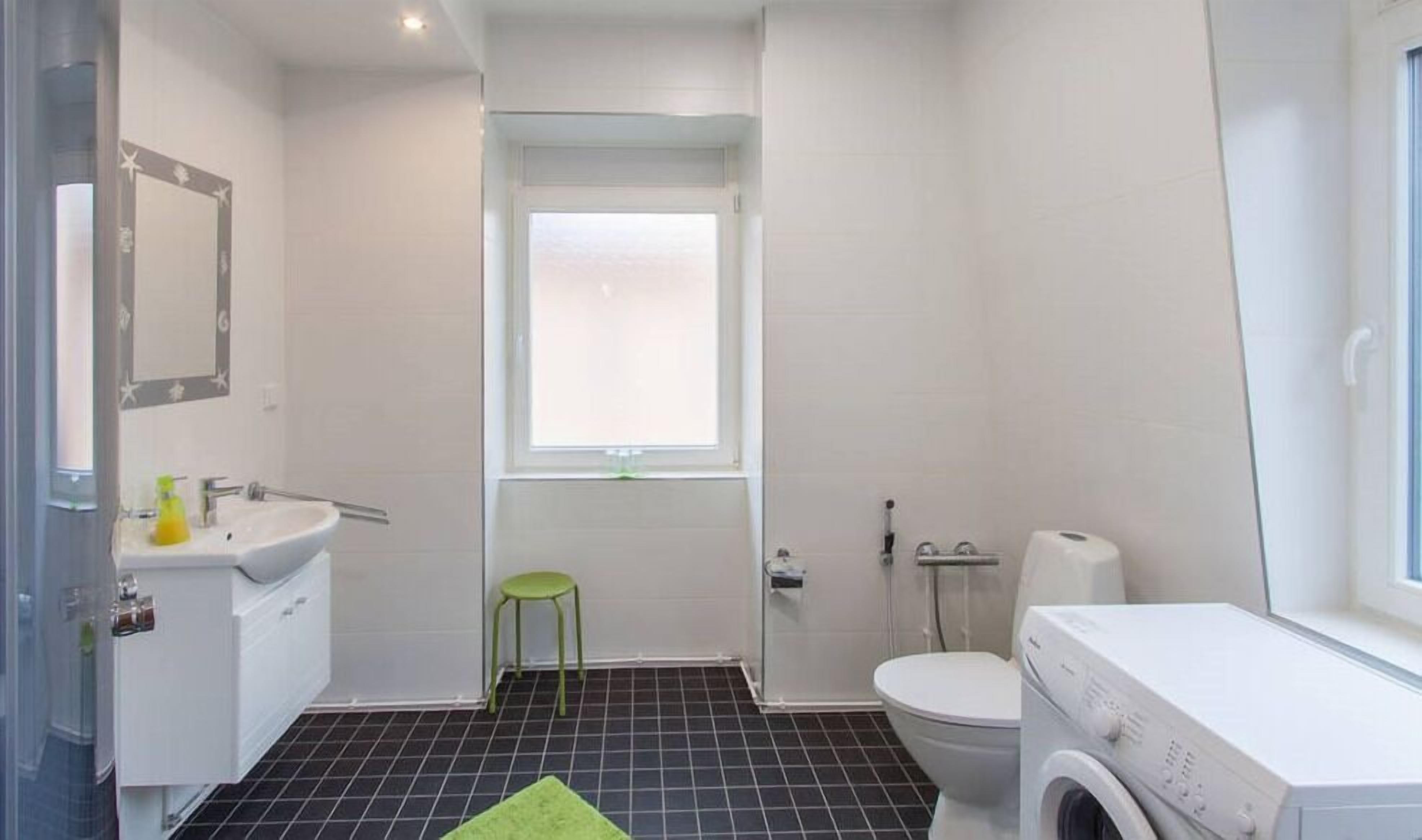 Un baño pequeño con inodoro, lavabo y lavadora.