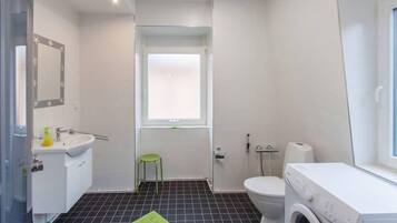 Un baño pequeño con inodoro, lavabo y lavadora.