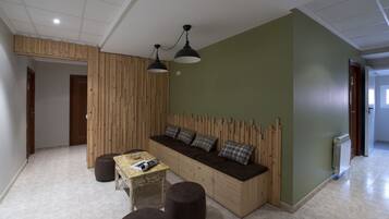 A modern living room with a built-in sofa, a small table, and two ottomans.