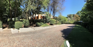 Stroll through the tranquil surroundings, surrounded by lush greenery and beautifully manicured hedges, to the entrance of this serene residential building.