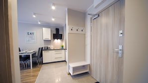 Een moderne keuken met witte kasten, een eethoek met een tafel en stoelen, en een inbouwbank.