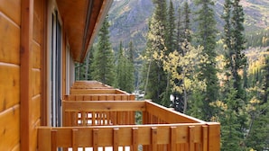 Een houten balkon met uitzicht op een bebost berglandschap.